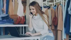 lead-follow-up-small-business-branson - Marketing Agency in Branson MO | Smart & Simple Communications - Marketing Agency in Branson MO | Smart & Simple Communications Small business owner taking a phone call from a new lead while working at her laptop in her boutique