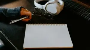 Writing a radio ad script - Smart & Simple Communications - Smart & Simple Communications Blank notepad, pen and headphones on a desk, ready for writing a radio ad script for a local Ozarks business