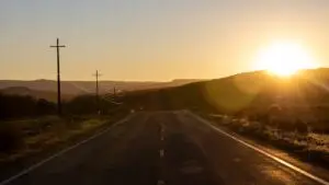 radio-vs-digital-advertising-branson - Smart & Simple Communications - Smart & Simple Communications Two-lane highway through low wooded hills at golden hour, the evening drive time when local radio reaches Ozarks commuters.