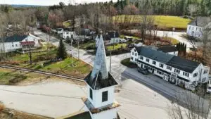 business-not-showing-up-on-google-maps - Smart & Simple Communications - Smart & Simple Communications Aerial view of a small American town at a crossroads, white clapboard buildings and a church steeple surrounded by wooded hills