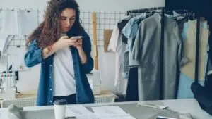Social Media Management for Small Business: What It Takes - Smart & Simple Communications - Smart & Simple Communications Small business owner photographing her own products with a phone in her workshop, the weekly content work behind social media management